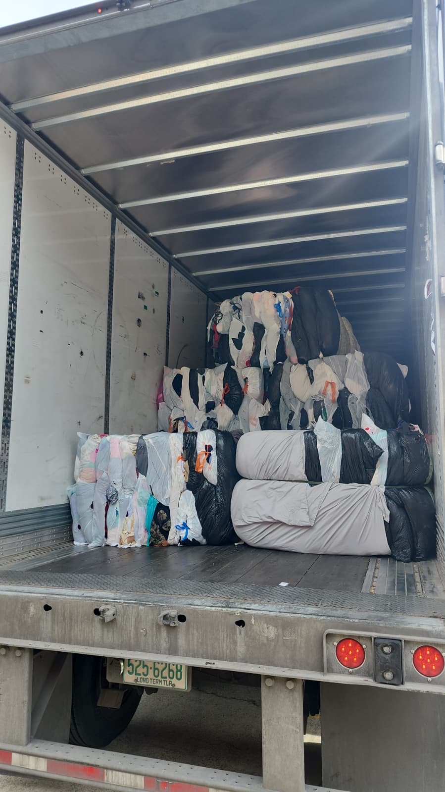 NBR Global crew in safety vests loading bagged textile donations into a 53-foot trailer at the dock